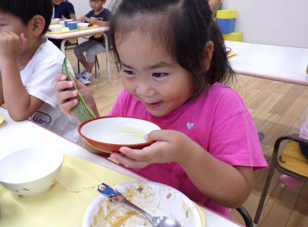 給食時間に「どこのクラスをのぞいてみようかな～」と思いながら歩いていると、
4歳児の保育室から、
「今日メロンある！！」「たのしみ～」と聞こえてきました。

その声に誘われてゾウ組さんの保育室へ♪
入るとさっそく、
「先生、これ見て！メロンのジュース♡」
とメロンが入っていたお皿を見せてくれたSちゃん。
見ると、お皿にはメロンから出た果汁が♡
「ほんまじゃね。メロンの香りもしておいしそう！飲んでみる？」というと
「絶対おいしいよね！飲んでみる！」とお皿を口元へ・・・
次の瞬間、「にこ～♡」っと、とびっきりの笑顔に。
何も聞かなくても「おいしかったんじゃね」と伝わりました♪