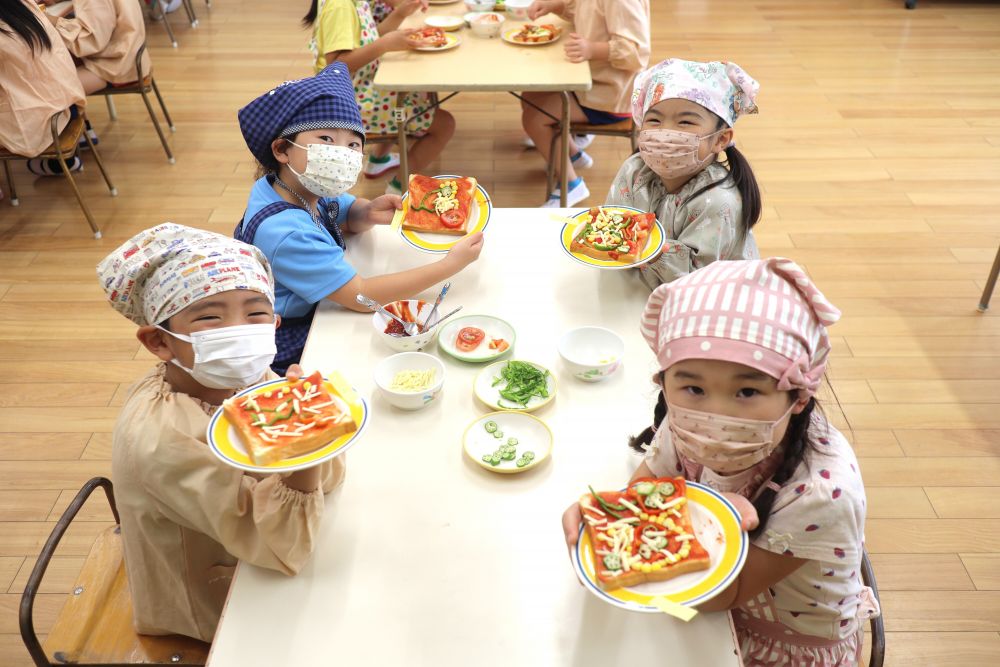 その他にも「花火」「ひまわり」など、夏らしい作品もたくさんありました。
子どもたちの発想の豊かさには、毎年驚かされます。

苦手な野菜もあったようですが、「この色が使いたいけぇ入れるしかないか・・」と言っている子や、友達が使っているのを見て「私も使おうかな・・」と勇気が出た子もいました。
クッキングを通して、苦手なものへの挑戦もできたようで、嬉しいです♡

グループのみんなと楽しみながら作ったピザ。焼き上がりが楽しみだね！