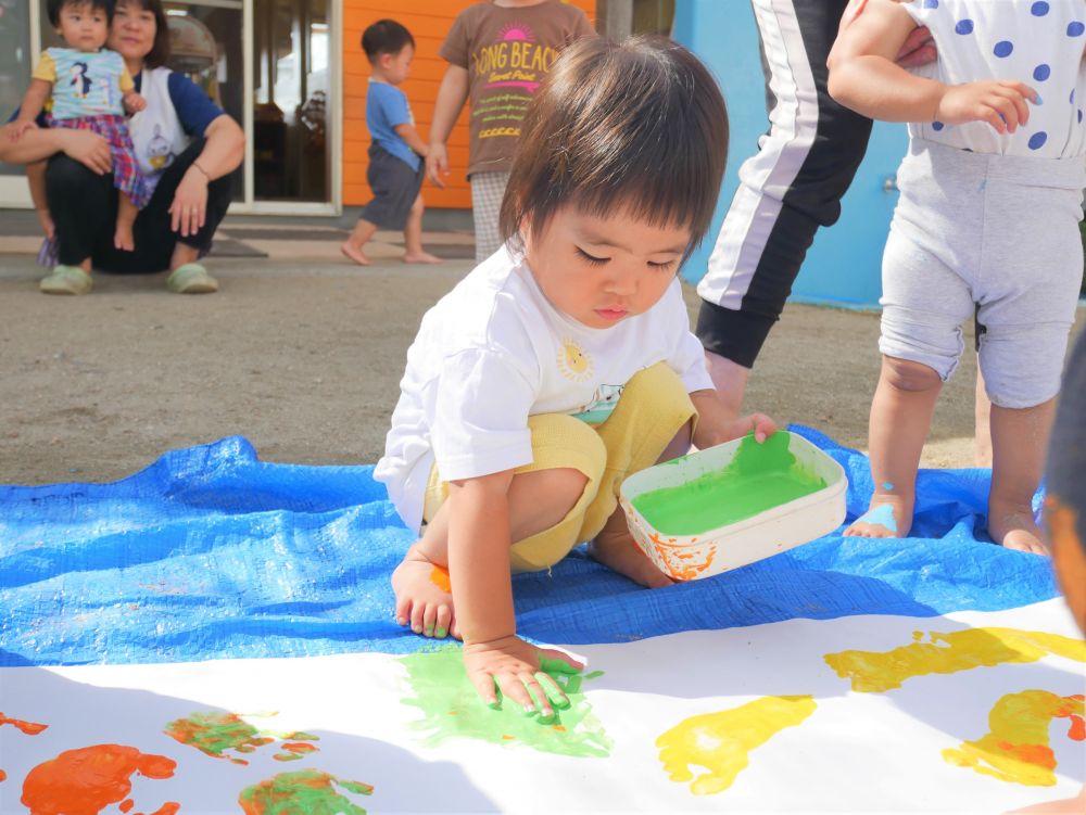 黄緑色が気になっていたのかな？
絵の具の入った入れ物を片手で持ち
ちょんちょんとつけながら
手でひらで絵の具をグルグルのばす