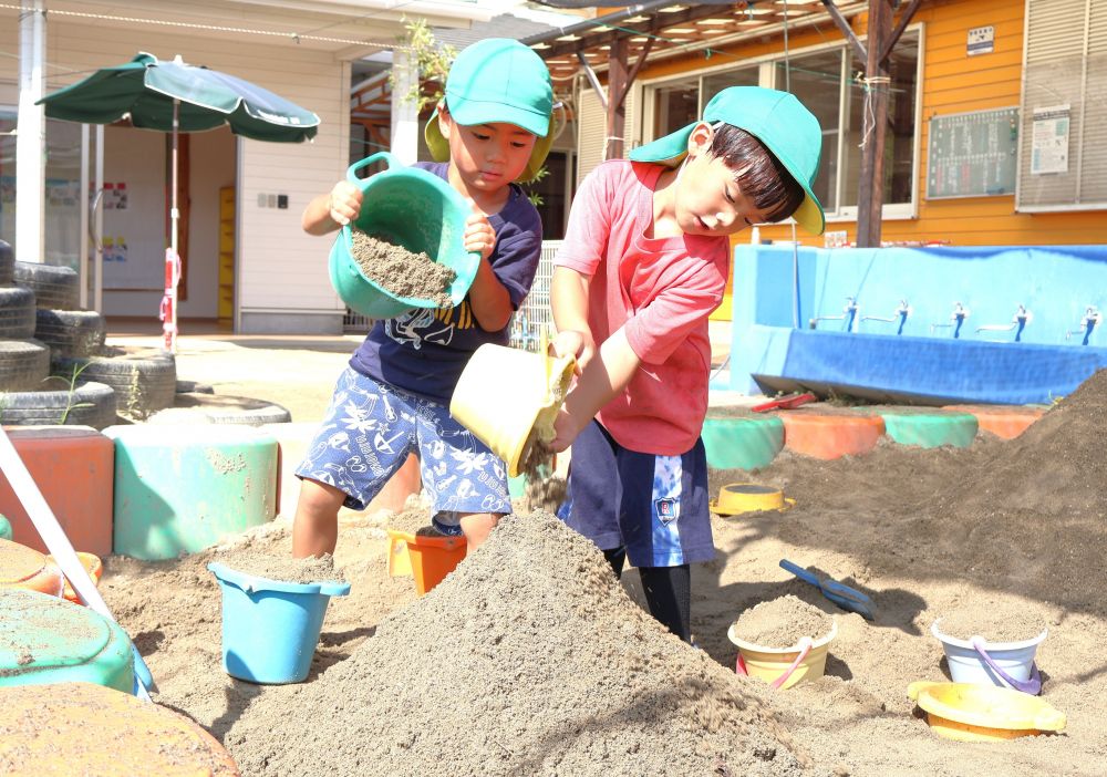 　「もっと大きい山作ろーや！」
友達の姿を見て、参戦☆
　「バケツに集めてから、どんどん乗っけよー！」
　「この方が速いもんね！」

自分たちなりの方法を見つけたり
良いなと思ったアイディアに共感したり・・・♡