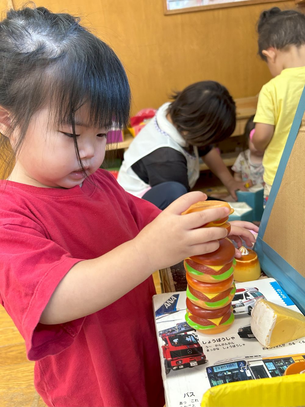 おままごとコーナーでも真剣に積んでいる
お友だちがいます！

Tちゃんはハンバーガーを、倒れないように
ゆっくりゆっくり…バランスをとって
そっと積み重ねていました。

途中で倒れると、
「たおれちゃった！」
と、言いながら、何度も
繰り返しチャレンジしていました😮✨