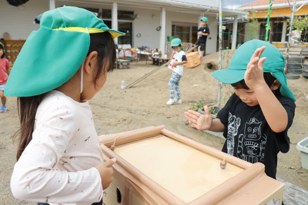 その横ではドングリゴマを何度も何度も回して遊んでいます
回し方も上達しています
また、微妙な形の違いや重心の違いでよく回るコマとそうでないコマがあります
そんな違いを感じながら・・・