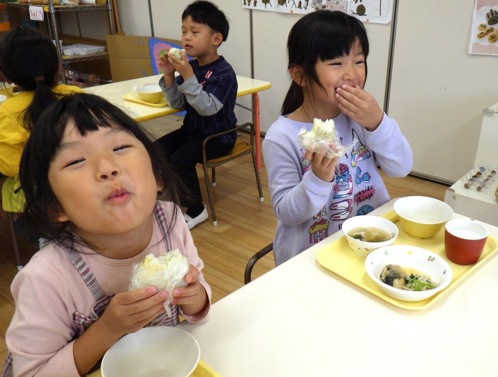 できたておにぎりは、その日の給食と共に・・・。
村上のおじいちゃんに、秋の味覚に、感謝の気持ちを込めて
「いただきます！」

一口食べて、この表情♡
おいしさ、嬉しさ、満足感、いろんな気持ちが伝わってきます。
「あまくておいし～い！」
「また絶対作ろ～」と、大満足のキリン組さん。

食欲の秋、まだまだ楽しみます♡