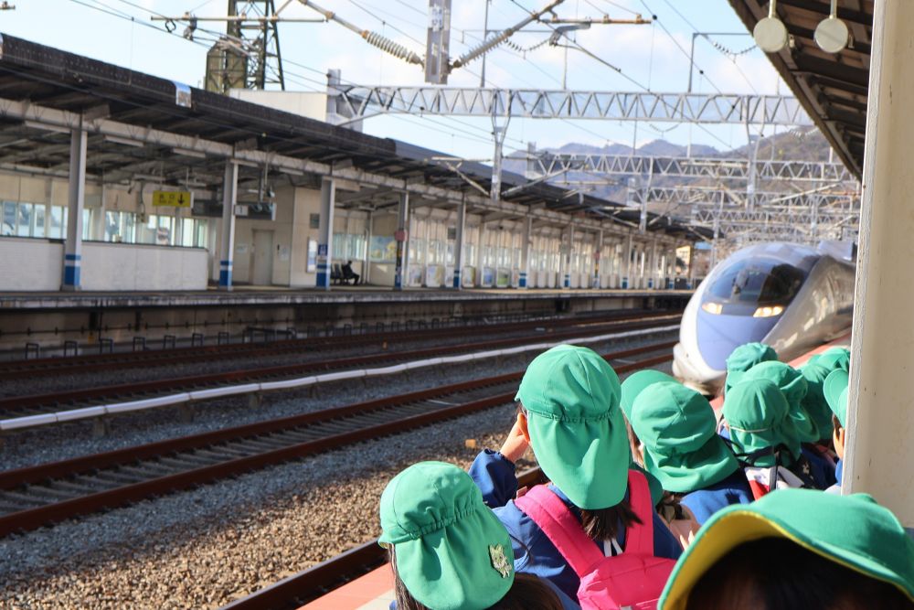 いつも散歩で見に行っている新幹線。
今回は駅のホームまで入らせてもらい、さらに近くで👀！

「もう来るかね♪」
「ちょっとドキドキしてきた」


もっと身を乗り出して見たいけれど、
　　"黄色の線の内側で”
駅員さんとの約束をしっかり守って、線路の先をじっと
見つめる子ども達・・・


