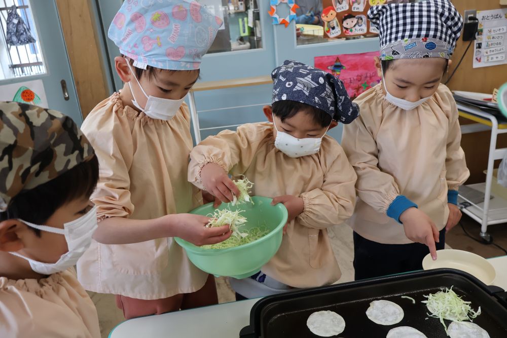 【焼く】係の中でも
さらに自分たちがやりやすいようにと

・餃子の皮をのせる人
・キャベツをのせる人
・かまぼこをのせる人

と話あって分担していた子どもたち

「ここキャベツ少なくない？」
「ボール持っとくよ」
など友達と協力して進めていきます
