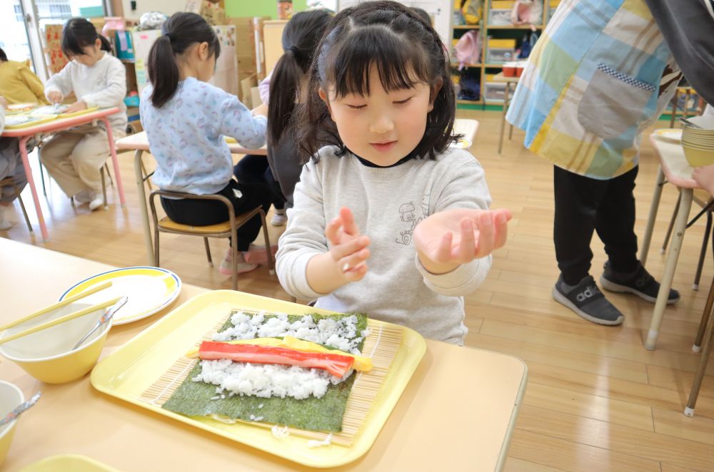 「ご飯はこんな感じ？次は具を置くんよね？」と、
ひとつひとつ工程を確認しながら進めていく子ども達。初めての経験に、慎重です。

「あ、ご飯粒が手についた！」
「あ、まきすも一緒に巻き込んじゃった！」
などなど、色んなハプニングもありながら・・・♡