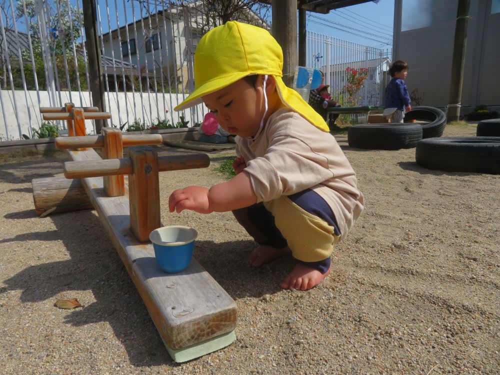 何かおもしろいことはないかな・・・
アンテナをはって周りの環境を探る子どもたち
今日はどんな発見があるかな?
地面に目をやってお気に入りの石を見つけたGくん
Gくんはカップに入れたり、手に取って確かめたり♪
その石の形や色がGくんにとってとても魅力的なものでした!