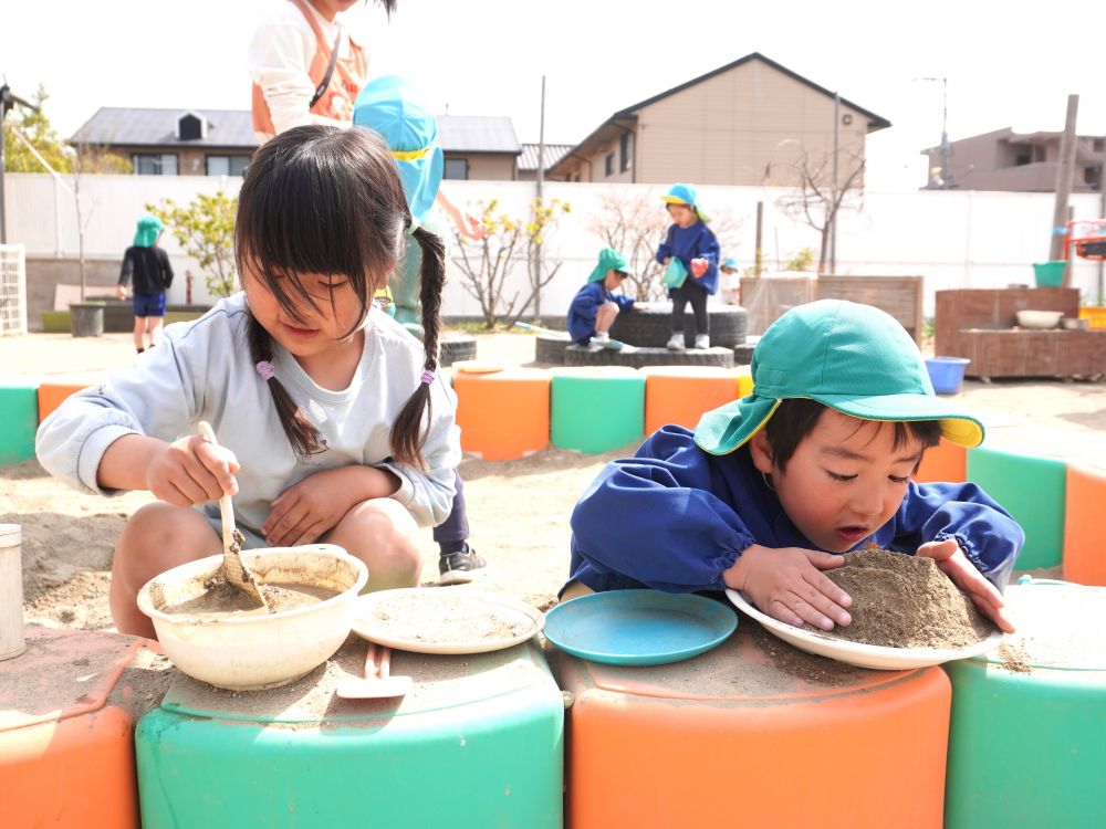 砂や泥を使って…
「さらさらの砂じゃ固まらんけケーキできんくない？」
「水入れたらドロドロになるよ～」
「手でパンパンしたら固まりそう！」
それぞれのやり方でごちそう作りを楽しむ♡