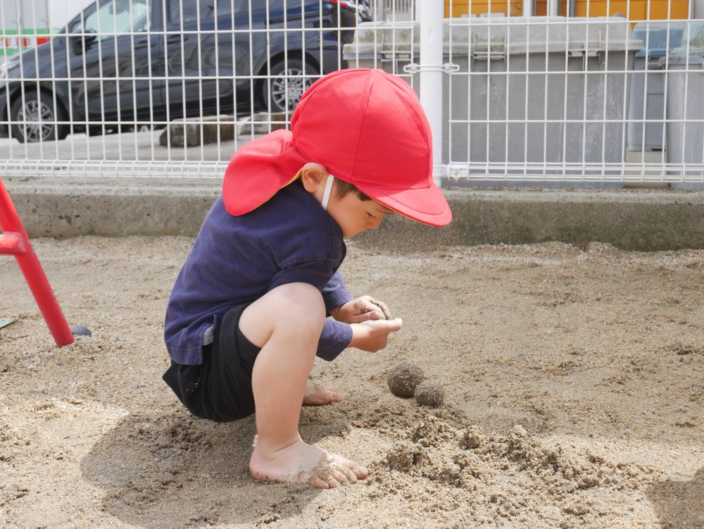 “やってみたい”
他のクラスの子がしている所を見て
興味を示し自分でも試してみる!!
『僕のお兄ちゃんがどろだんご作ってた』
弟のHくんも挑戦!!
『ぎゅっと握ったら丸になるんだよ』
自分なりにコツを掴んでどろだんごを作ります
両手に力が入っている様子が写真からも伝わってきます