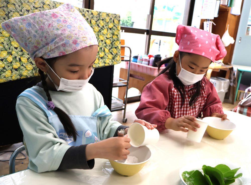 5月5日は端午の節句でした。
子どもたちの健やかな成長を願ってかしわ餅やちまきを食べてお祝いします。
園でもキリン組さんと【かしわ餅作り】に挑戦しました。
キリン組さんになって初めてのクッキング♡
エプロン・三角巾は慣れた手つきで準備万端!!しっかりアルコール消毒も忘れません☆
まずはかしわ餅の材料の説明をしました。
上新粉と白玉粉と水で作ります。
上新粉を触って・・・
「わーさらさら~」
「ふわふわしとるねー」
白玉粉を触って・・・
「ざらざらしとる」
「ゆびでつぶれたー」
上新粉も白玉粉もどっちもお米のだよと伝えると
クンクン・・・
「ほんまじゃーごはんの匂いがするー!!」
いろんな発見がありますね♡