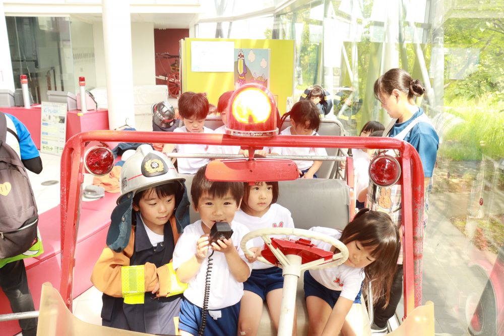 少しよそ行きの子ども達、仲良く順番にミニ消防車に乗って楽しみます
サイレンを鳴らしたり、マイクで喋ったり
これも消防士さんになりきっています
夢中な時の子どもの顔は何ともステキです