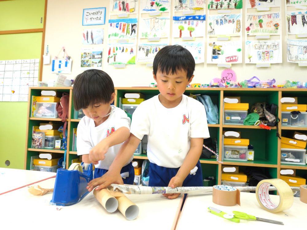 頭の中でイメージできていても
何を使おうか…どう組み合わせようか…
大人でも悩み苦戦する工作ですが
子どもの柔軟な発想って本当にすごい!!
新聞紙… 芯… トレー…
いろいろな廃材を組み合わせて考えながら作っていく2人・・・
話したり相談したりする姿もなくそれぞれが黙々と作る!