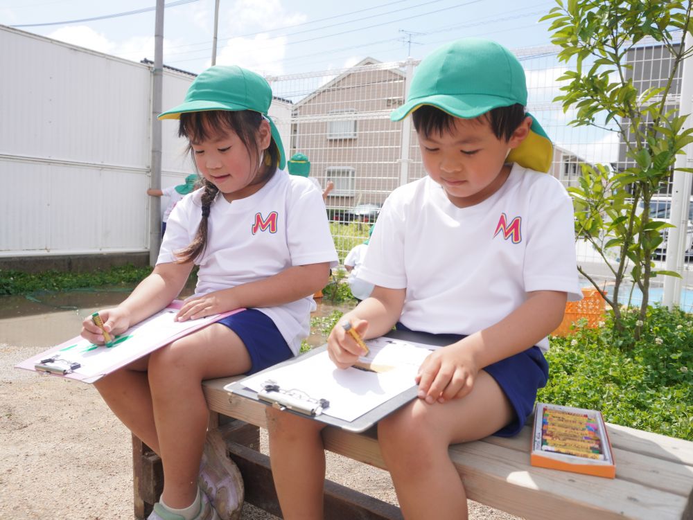 観察して・・・ 気付いて・・・ 記録して・・・
絵で表現したり文章で説明したり
文字を書ける子も… 難しい子も…
少しずつ遊びや生活の中で文字にも触れる機会を作っています♡
「あっ大きくなってる!」
「この前は芽だけだったけどきゅうりができてるよ!」
「小さいのかわいいね♡」