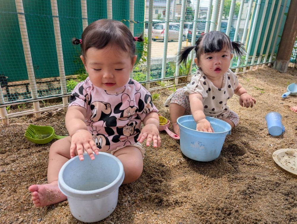 バケツの中の水を触ってみようかなあ~?
2人とも最初は慎重に…
少しずつ慣れてきたら
水を「バシャ、バシャ」したり、
砂を中に入れて混ぜ混ぜしたりして遊んでました。