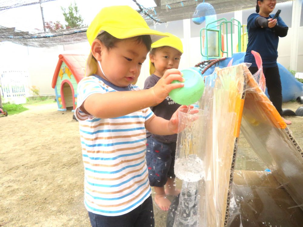 色々な形のペットボトルに順番に水を入れ
どんな風に水が落ちていくか観察中…
一通り水を入れ終わり一番のお気に入りを見つけたN君
シャワーのように水が出てくるペットボトルに繰り返し水を運んでいきます