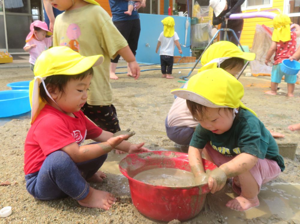 “水と土を混ぜるとどうなるだろう”
その不思議さ、おもしろさに遊びの中で出会う子どもたち
ベタベタ・・・ドロドロ・・・
肌で感じて、子どもたちの好奇心を刺激しています!
洗面器にたまったどろんこ
粘土質の土を水に溶かしてトロトロ~!
「気持ちいい!!」
たまらず腕をうずめるYちゃん♡