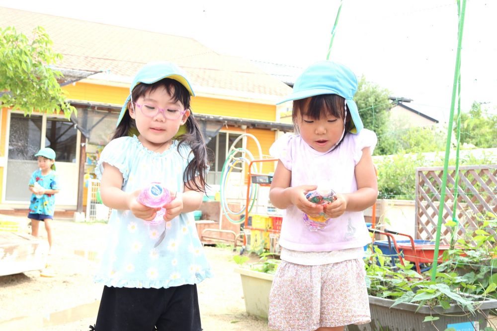 見て、触って、感じて全身で楽しむことのできる水
子ども達も目を輝かせながら、友達と一緒に大はしゃぎ!
「どうやったら出てくるんかね~?」
「水をいっぱいにして押したらいいんじゃない?」
ペットボトルの向きを変えてみたり
水の量を増やしてみたり…
友達と話しながらやってみる!