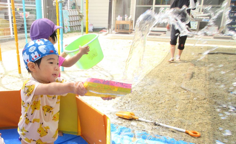 何度もプールに入って遊ぶ中で、少しずつ水に慣れる姿がみられます
遊び方もだんだんダイナミックになってきました♪




水をすくって飛ばすのが楽しいS君
ゆっくりと水をすくって、両手を使って思い切り振る！！
水がバシャっと飛ぶ動きや様子を興味津々にみつめます
繰り返すうちに、遠くまで水が飛ぶようになるのがまた楽しいようです！


