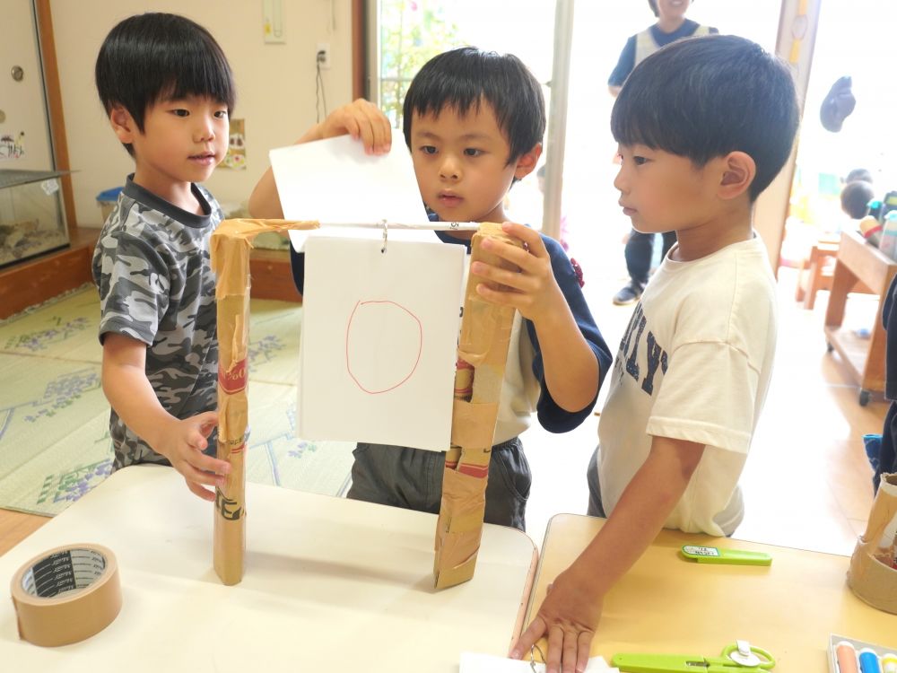 先生が入る隙もないくらい自分達でどんどん進んでいって
意見を出すこと… 受け入れること… 考えること…
子ども同士で話し合いながら協力できる力が身についてきています♡
「得点板も作ろう!」
「ダンボール丸めて…」
「広告で棒作るわ!」
どんな得点板にするんだろう…そっと見ていると
これまたどんどん進んでいてすごすぎる得点板ができてた!
こんな発想できる!!??天才です!♡
先生達みんな感激・・・
