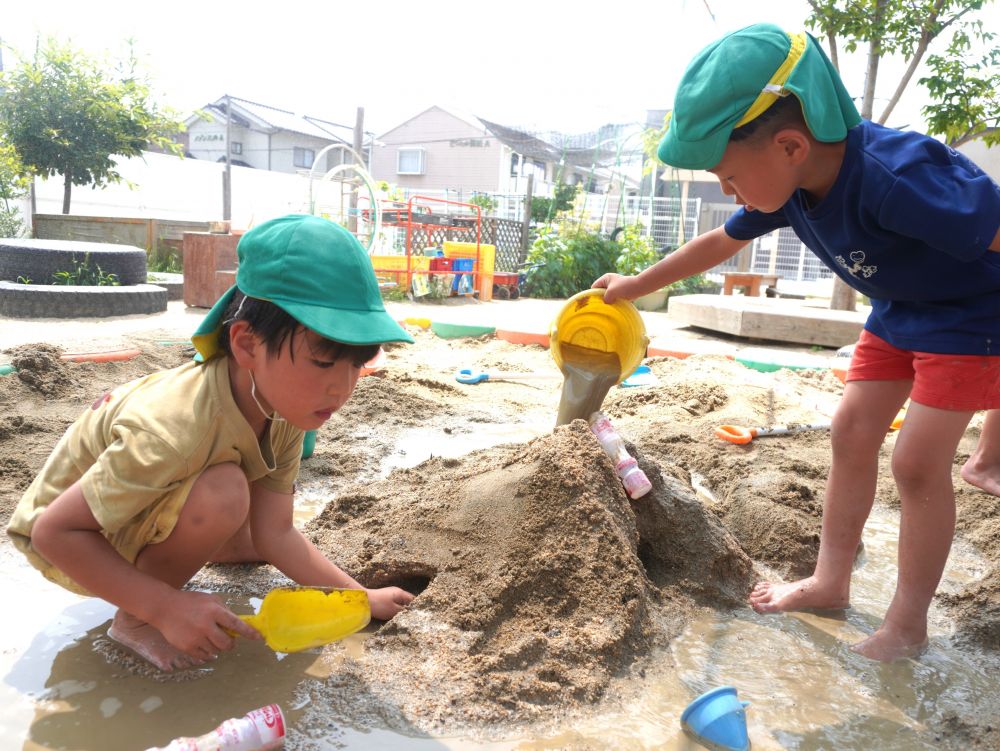 「水流してみよ!」
やってみると・・・
「道から水が溢れた…」
「山が崩れていった…」
どうしようか悩んでいると
「水はちょっとずつ流さんと!」
「山はもう少し固めた方がいんじゃない?」
「水遊びで使った流れるやつ(トイ)を使う?」
他グループの子が一緒に考えてアドバイスをくれました♡