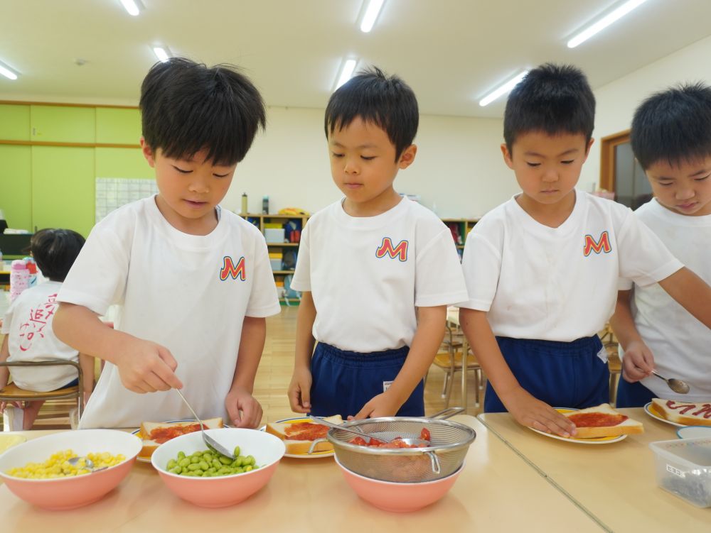 着替えが出来たら朝ご飯の準備です☆
みんなが園庭で育てた夏野菜…
パンにのせてピザにします♡