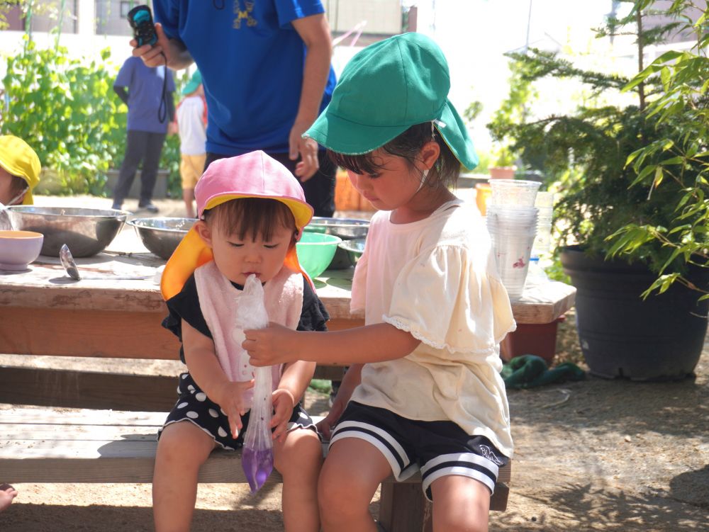 「色水したい?泡したい?」
「これ使って良いよ」
「次はこうするんだよ!」
積極的に声をかける女の子チーム♡
言葉も行動も小さいクラスの子を思いやっていて優しい♡
「すりばちよりも袋のほうがやりやすいよ!」
モミモミしやすいように持ってあげる♡