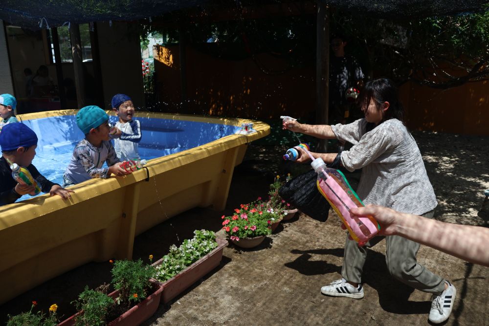 すると…プールの外から水が‼
お家の方も水鉄砲に参戦♪
子どもたちは大喜びで
「わーー！やられた！やり返しだ」
と反撃開始です

お家の人と一緒に楽しむ姿は
猛暑日の太陽にも負けないくらいの
キラキラ笑顔でした✨

