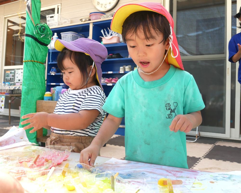 冷たい氷の感触を楽しんだり
次第に溶けていく不思議を感じている子どもたち
『あれ?絵を描いていると段々氷が溶けてきたぞ・・・』
『じわ~って絵の具が広がった♡』
この絵・・・なんの絵にしようかな・・・