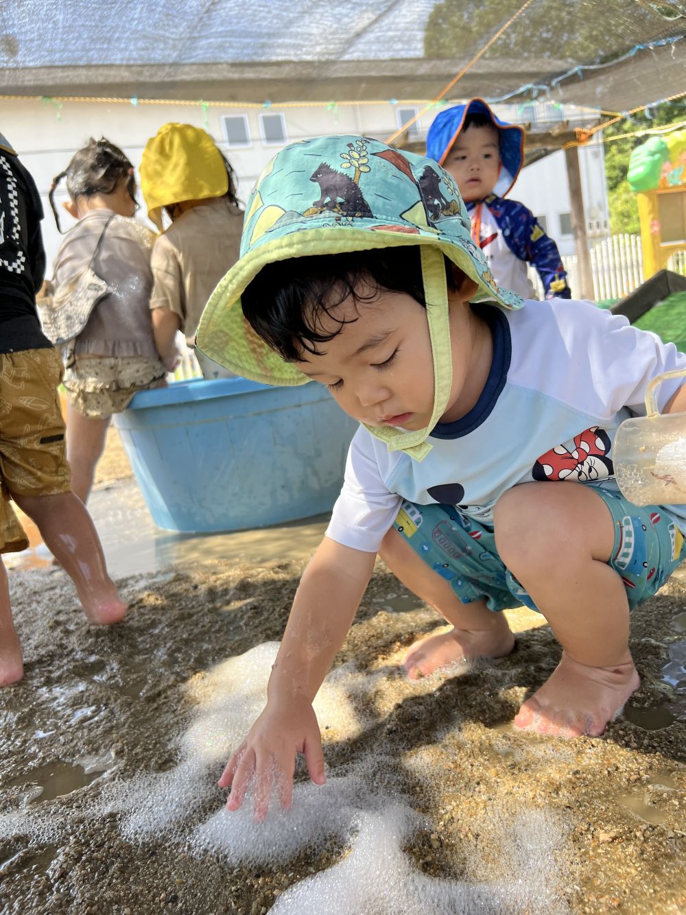 Yくんは地面の上の泡を一生懸命集めて、
コップに入れようとしていました。