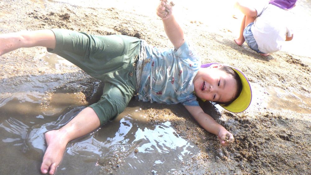 園庭に出て、それぞれが好きな遊びを見つけて楽しむ
この夏、裸足で園庭に出ることが苦手だったK君も少しずつ感覚に慣れ、砂場にできた
水溜まりでペットボトルのふねをうかばせて楽しむK君でしたが、気が付くと全身みずたまりに寝そべって全身でどろんこ遊び!
泥や水の感触に慣れとっても気持ちよさそうに楽しむ♡