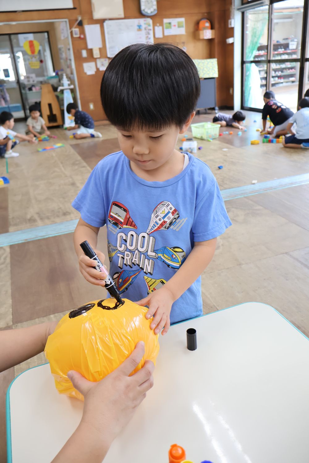 田んぼに植えた稲にお米ができはじめました。
「きいろ(黄金色)になったら収穫しようね。
   あーでもすずめが食べに来ちゃうかも…」
そんな保育教諭の言葉に
「かかしがあったらいいのに💡」と
答えてくれたのはＨくん

さっそく顔作り🎶
カラーポリの色を選んで顔を描きます