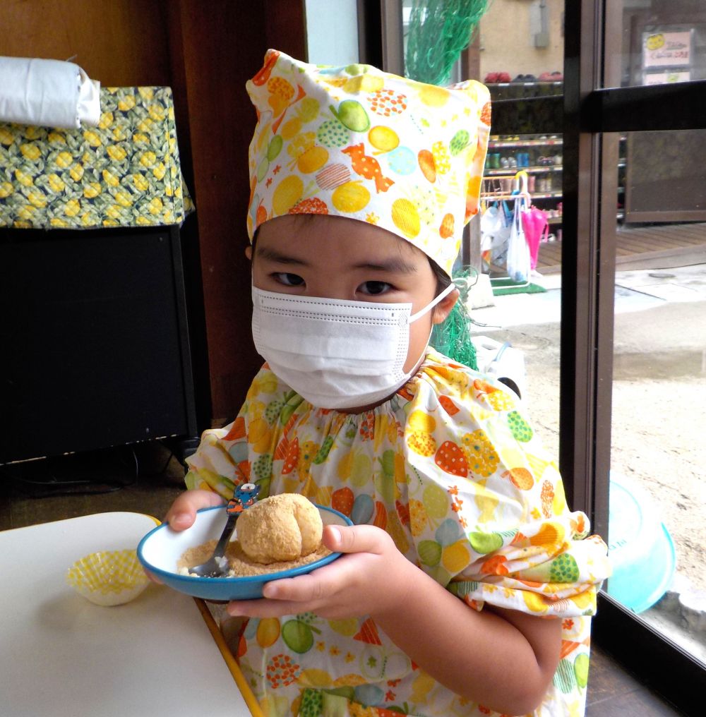 ラップの上にのせたご飯を両手を使ってでぺったんこ☆
しっかりつぷしてもいいよー
「おいしくな~れ おいしくな~れ♪」
思わず口ずさむゾウ組さん♡
次は丸めたあんこをご飯の真ん中にのせましょう。
のせたらごはんで隠していくよー
「あんこが出たー」
「ごはんが手についたー」
いろいろありましたがちゃんと丸めたご飯の完成!
最後はみんなの大好きなきな粉をまぶして出来上がり♡