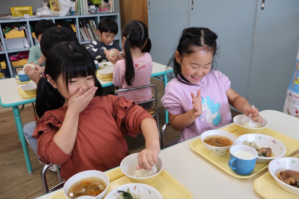 目で見て、匂いで感じて ・ ・ ・

次はいよいよおにぎり作り開始！
ごはんをラップにくるんで
それぞれが好きな形に握ります！

炊き立てホカホカごはん！

「あっつ〜い！」　「ちょっと冷ましながらしよう！」
「あ〜、はやく作りたい〜♡」

焦る気持ちを抑えつつ
“フ～ フ～！”と冷ましながら
友達と一緒におにぎり作りを楽しんでいます
