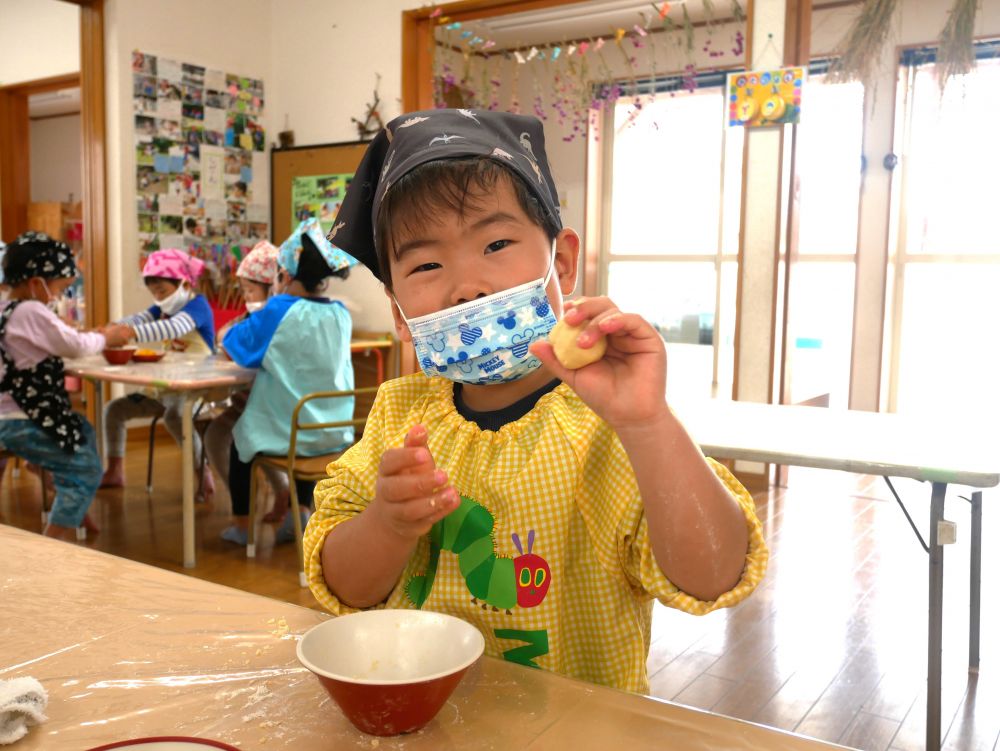 お椀の中で材料がまとまってきたら、今度は手でこねていきます。
粉っぽさがなくなるまで、しっかりこねこねモミモミして、ひとつの生地ができあがります。
「見て！まぁるいだんごになったよ！」と嬉しそうに見せてくれます。
黄色い、レモンの香りがする生地ができあがりました♡

