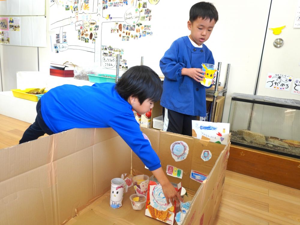 描いた絵をカップに貼って…
段ボールに貼り付けて…
どんどん形になっていきます☆