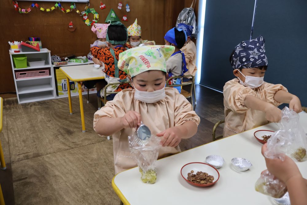 さつまいもde松ぼっくり！✨

さつまいもの生地に慎重に砂糖を
いれるⅯちゃん🥹ドキドキだね…♡

さつまいもを松ぼっくりカラーに
変身させるのは…ココアパウダーです🪄

慎重に…こぼさずにいれられるかな…