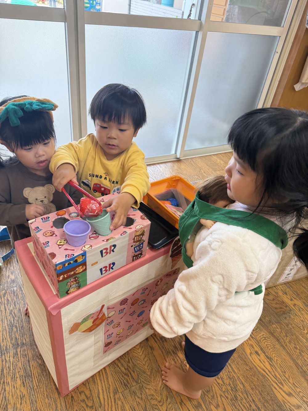｢いらっっしゃいませーあいすでーす｣と、
お店屋さんのIくんと、Tちゃん🍨

｢あいすくださーい！｣と、
赤ちゃんを抱っこしたお母さんのRちゃんが、
やってきました👶

お店屋さんとお客さんのやりとりも、
上手になりました♪
