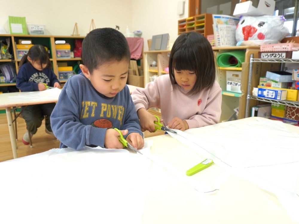 凧あげやかるたなどの正月あそびを楽しんでいます♡
”よく飛ぶ凧を作るには・・・”
素材を試したり工夫したり先生も子どもたちと一緒に考えています♡



凧作り！！自分で土台から作ります！
ポリビニール袋を切る作業…　これが結構難しい！！
ガタガタになってしまったり・・・
線からはみ出してしまったり・・・
でも集中して頑張った！！


