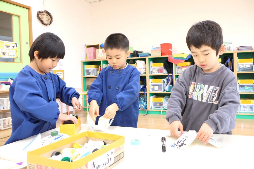 　「真ん中にキャップつけたほうがいいんじゃない？」
　「この斜めの方が回りそうよ～」
テープの長さやキャップの位置を考えながら
より回るこまを作る！