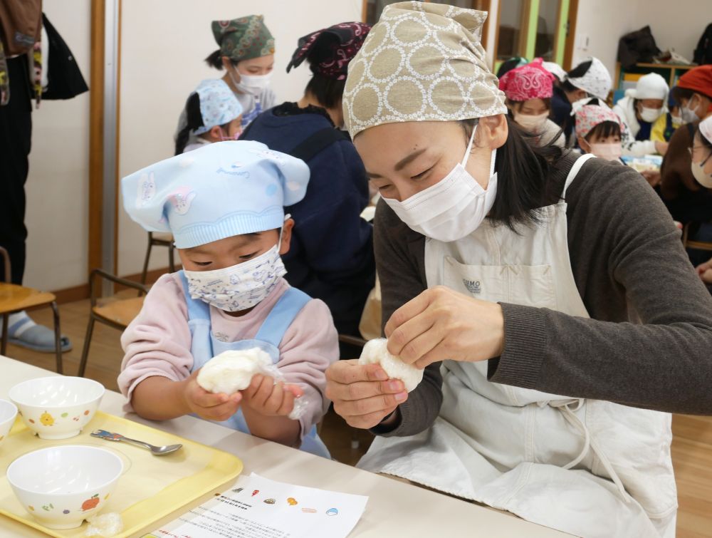 保育参加後に“親子クッキング”を行いました♡
「親子で“食”に関わる楽しい時間を過ごして欲しい！」という思いからスタートしたこの行事。「上手に」よりも、「楽しく」できることを大切に・・・♡

友達とするいつものクッキングと違い、今日はおうちの人と・・・。
エプロンに着替えて、普段と違う慣れない雰囲気に不思議な感じ♡
ドキドキワクワクの気持ちで、【ライスピザ】作り、スタートです☆
