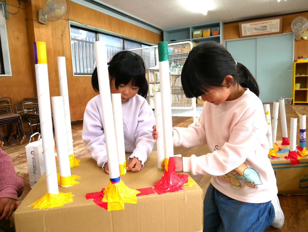 わっかを入れる棒はラップの芯で！！

試しながら作っているわなげチーム
わっかを投げると倒れてしまう棒
「グラグラするけしっかりとめよう！！」
まずは土台をしっかり強くする女の子♡