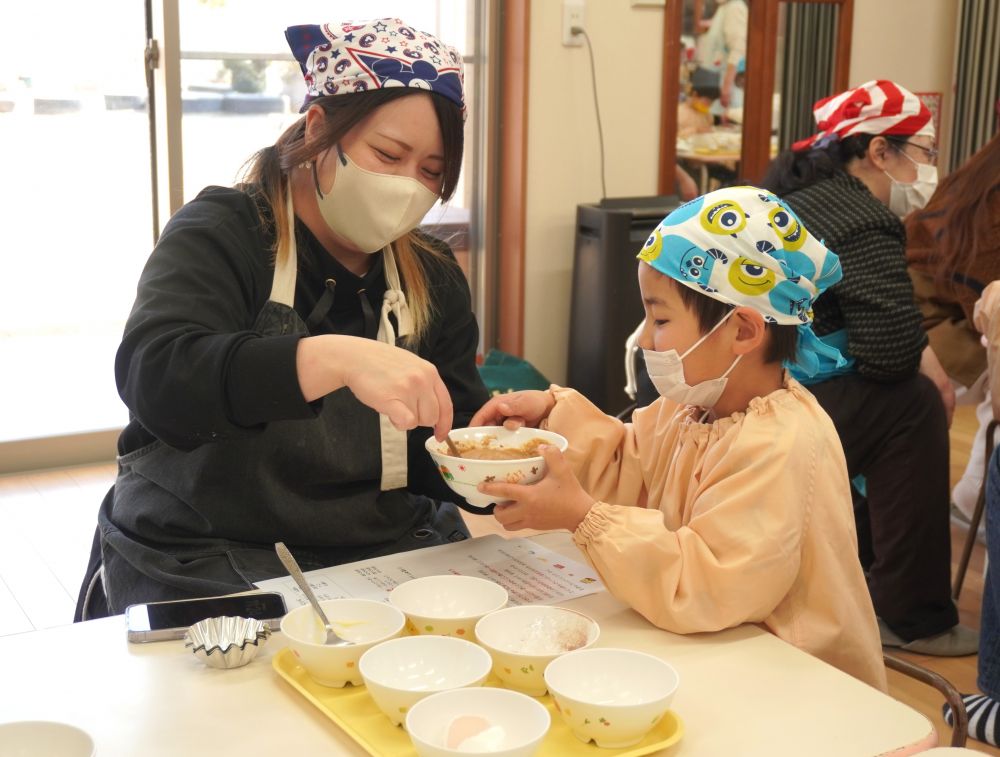 材料がそろえば、後は混ぜるだけ！ なので、意外と簡単に作れるココアマドレーヌ♡
作り方の紙を見ながら、順番に混ぜていきます。

全部の材料を入れ、なめらかになるまでひたすら混ぜ混ぜ！ちょっと粉のダマが気になる子ども達。そんなときはおうちの人に助けてもらいます♡
K君もお母さんにバトンタッチ！すごい勢いで「ぐるぐるぐるぐる～！」と混ぜてくれて、あっという間になめらかに♪
見つめ合っったり笑い合ったり、親子のほっこりする時間が流れていきます。