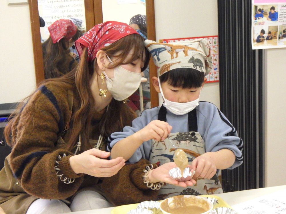 できあがった生地を５個のアルミカップに分ける作業。
一つのカップにどれくらい入れたら良いか、考えながら入れていきます。

生地がこぼれないように頑張って入れるYくんと、アルミカップを持って優しくサポートしてくれるお母さん。
さすがの連携プレーで、きれいに分けられました♡