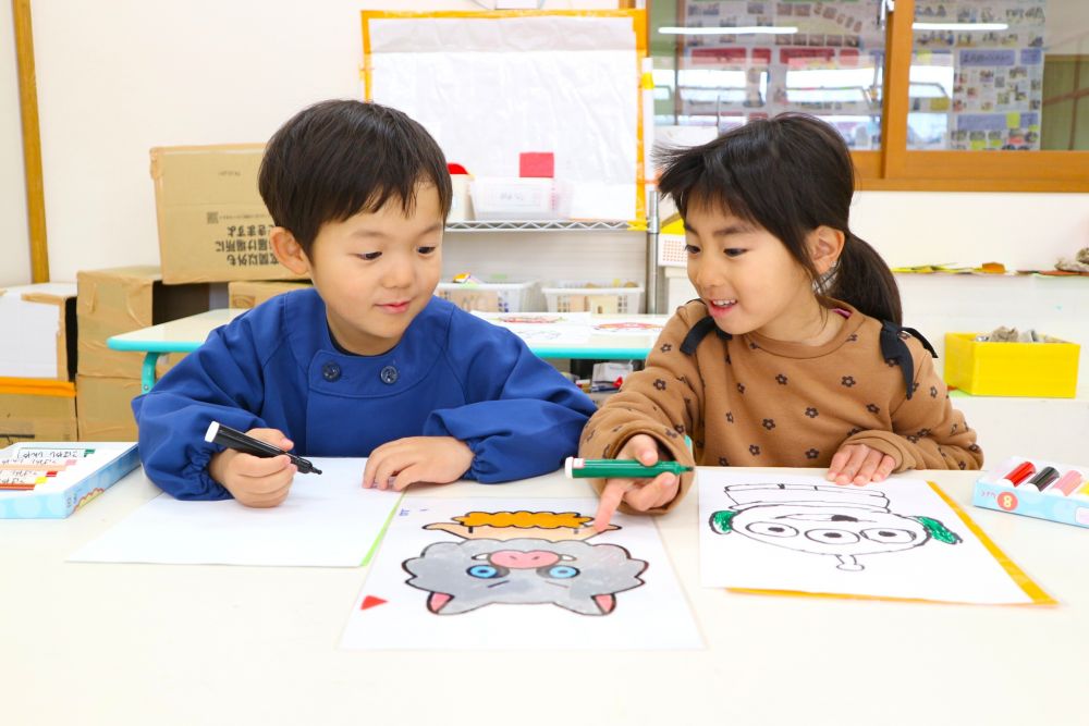 「ゴールに絵を描きたいけど・・段ボールじゃ難しいね・・どうする？」
「テープ貼る？」
「紙に書いてそれを貼ればいいんじゃない？」
「それ、いいね！」

紙に描く中でも
「上手く描けないかも・・」
「どうやって描いたらいいかわからん・・」
悩む姿もありながら・・
「教えてあげるよ！」
「お手本準備したらいいんじゃない？」
友達と一緒に　”こうしたらいいかも”　のアイディア考える姿
