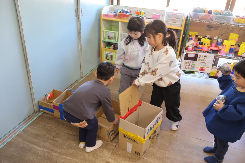的になる箱と景品を並べて準備オッケー👌
小さいクラスのお客さんには、当たりの箱を手前にしてボールが入りやすいようにひと工夫。

以前、キリン組さんが遊びに来てくれた時に
「どの箱が当たりかわからない」
とのご意見。
ゾウ組さん考えました。
「あたりって書く？」
「くまさんたちは字が読めないから印がいいんじゃない？」
そうして出来上がった当たりマークの〇印。
