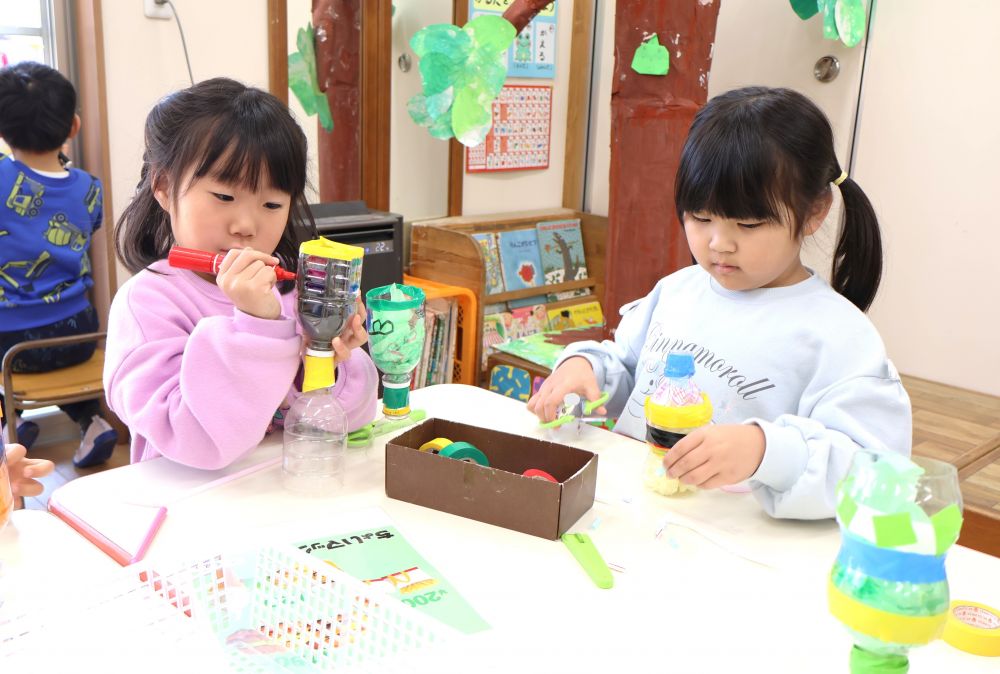 ジュースを作るなかでも工夫がいっぱい！
　「チョコシェイクは茶色だから…」
　「これだったら赤ちゃんでも飲めるでしょ？」
何味のジュースかが分かりやすいように果物やチョコの絵を描いたり
持ちやすい容器の形にしたりとアイディアがどんどん出てくる！