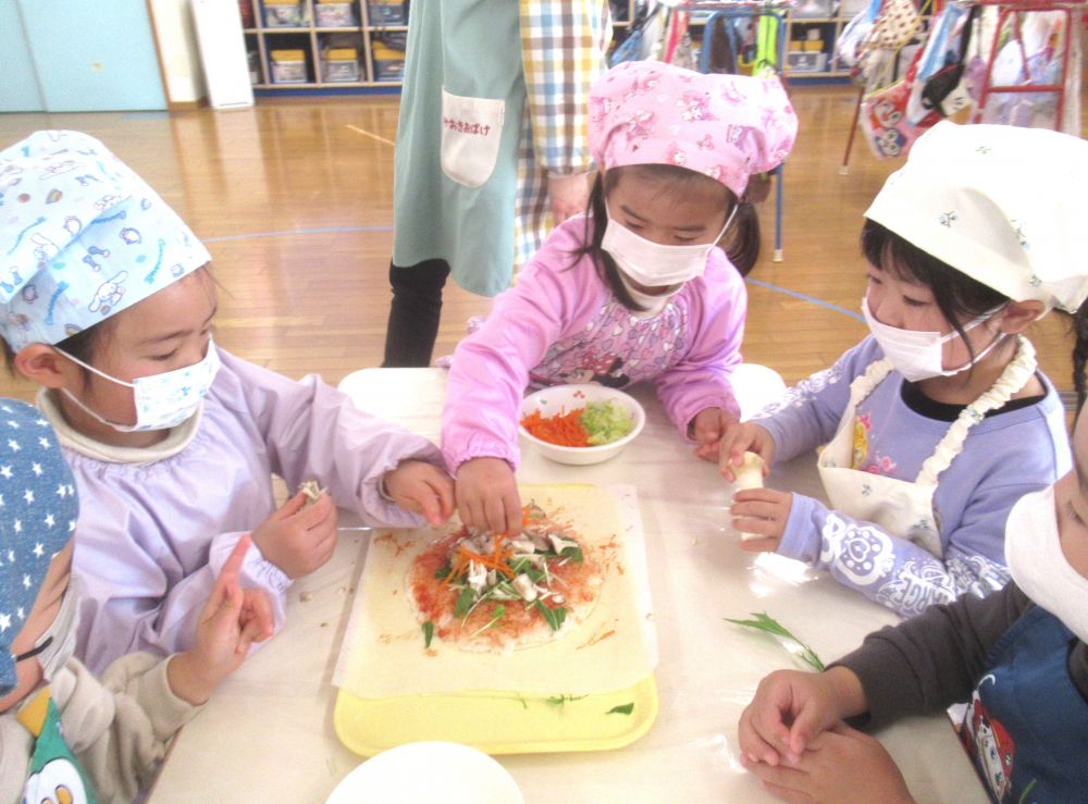 水菜・エリンギ、まいたけなどの食材は、ちぎって細かくするところから・・・
「みずな、プチプチって音がしておもしろ～い」
「まいたけってめっちゃ匂いするね！」
と、食材の違いを五感で感じながらご飯の上に置いていきます♪
白菜・人参・ウィンナーも彩りよくトッピング♡