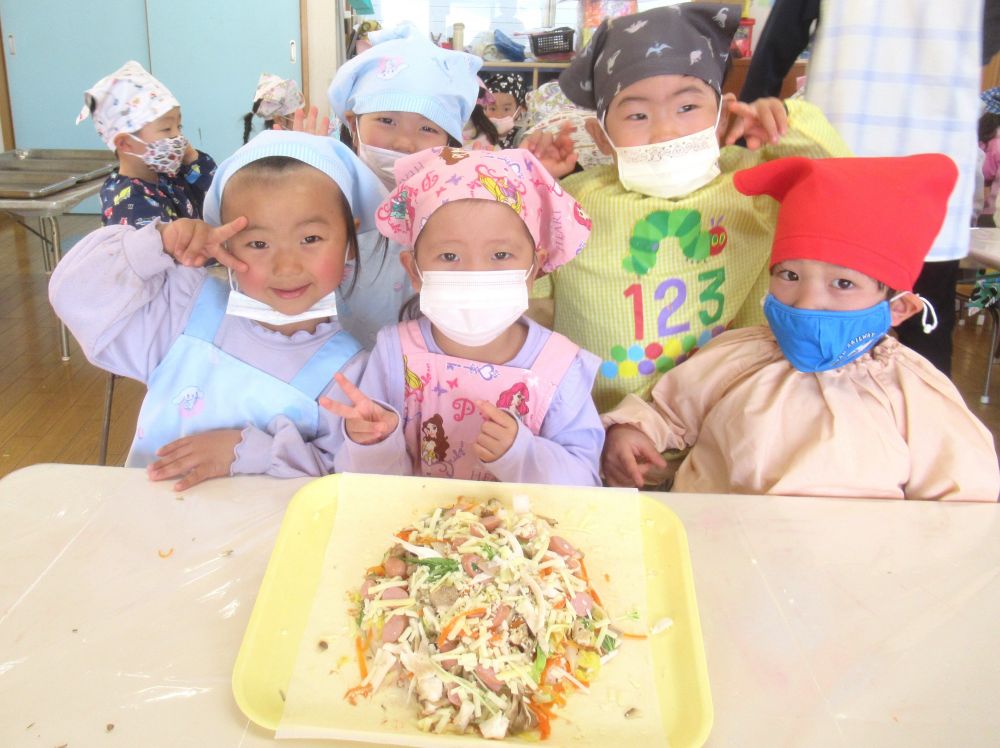 ついつい真ん中に集中してしまいがちなトッピング。
「ここ、具が少ないかな？はしっこまでおいしい味になるようにやってみよう！」
と言うと、
「こっちからウィンナー持ってくる？」
「きのこもっとバラバラにする？」
と、ご飯全体に具材がのるよう、友だちと相談しながら楽しむ子ども達。

具材をすべて使ってトッピングし、最後にチーズを散らして、彩りキレイに完成です♡

あとは焼くだけ！となったライスピザ。
「おいしそうにできたね！」
「楽しみじゃ～♡」
「早く食べたいね！」
友達とわくわくの気持ちを共有するリス組さん。