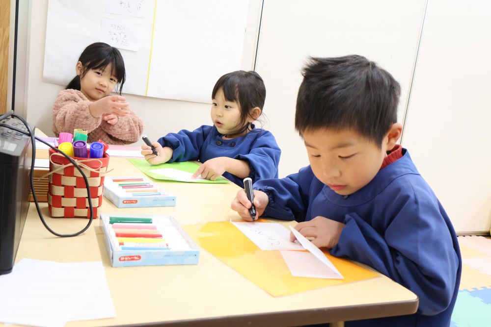 キリン組さんがしているリクエストメニュー、ゾウ組さんも参加♡
保育室の壁にメモを貼るスペースを作ってもらい、楽しんで貼ってくれました♪
あいうえお表で字を探すのはまだ難しいけれど、書きたい名前を先生に伝えて、お手本を書いてもらいます。それを見ながら書いているKくん。
「と・ん・ぺ・い・や・き」と読みながら先生の文字を真似て書きます。
とっても上手にかけてにっこり♡
