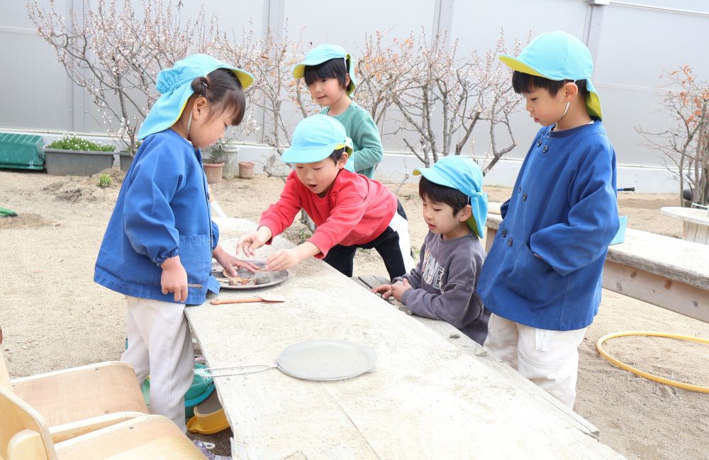 〈宝石屋さん〉
　「これ1つくださ～い」
　「お金と交換したら取っていいですよ」
　「お金3つ持ってきました！」
さまざまな形の石を宝石に、落ち葉をお金に
見立てて宝石屋さんごっこ
やりとりの中に自然と数が含まれていることに
びっくり！！